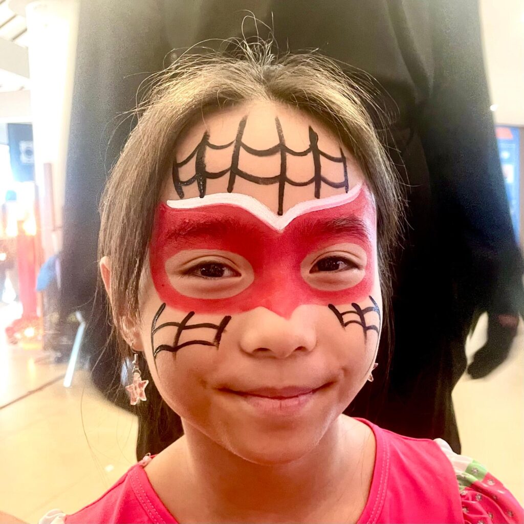 Facepainting for Children's parties by The Kindled Collective - spiderwoman design on face, halloween themed