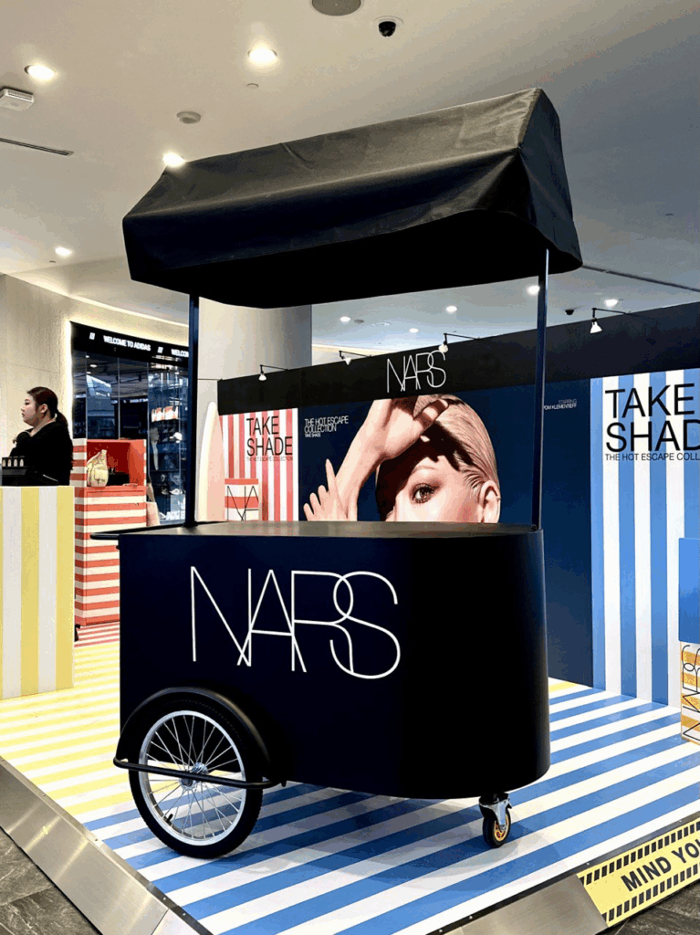 Black mobile pushcart with canopy roof, customised NARS wtie logo. Comes with large storage compartment. Fully customisable from cart body wrapping, simple logo customisation to printing of logo on the cart roof. Our pushcart is available in both black and off white. Perfect for reception tables, product displays, coffee cart, flower bars, or as a centerpiece to any event.
