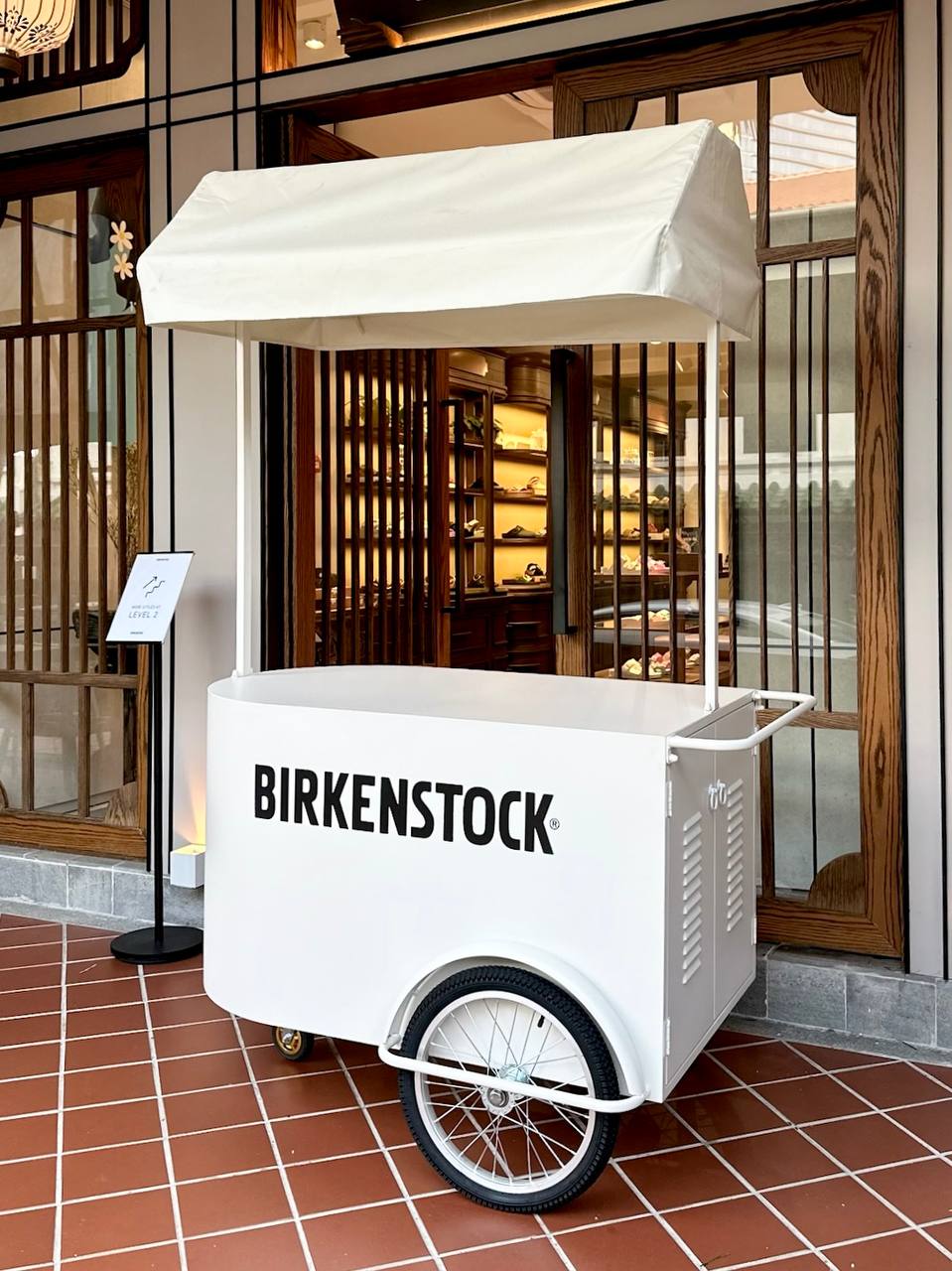 Off-white mobile pushcart with canopy roof, comes with large storage compartment. Fully customisable from cart body wrapping, simple logo customisation to printing of logo on the cart roof. Our pushcart is available in both black and off white. Perfect for reception tables, product displays, coffee cart, flower bars, or as a centerpiece to any event.
