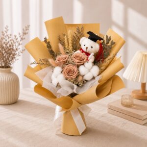 A graduation bouquet featuring a graduation bear, preserved blush pink roses, and rustic dried florals! Soft, elegant, and a heartfelt keepsake for celebrating their special day.